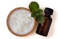 Coconut oil in a bowl with a wooden toothbrush and peppermint essential oil - Homemade natural toothpaste