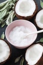 Coconut oil with fresh coconuts fruit on black stone table. Natural organic cosmetic for body care and beauty. Royalty Free Stock Photo