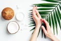 Coconut oil hand cream, organic cosmetic for skin care concept. Female hands applying coconut lotion or moisturizer over white Royalty Free Stock Photo
