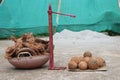 Coconut peeling machine with peeled coconut on one side and the dry husks leftover after peeling on the other side filled in a