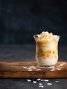 Coconut Pineapple, peach Trifle dessert mouse in a glass on a dark background with copy space. Vegan recipe dessert concept.