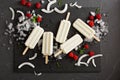 Coconut popsicles with raspberries on black background Royalty Free Stock Photo