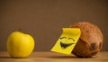 Coconut with post-it note laughing on apple