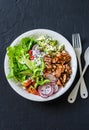 Coconut rice, grilled salmon and vegetables buddha bowl. Healthy lunch - rice, red fish, salad, avocado, radish, tomatoes on a dar Royalty Free Stock Photo