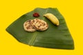 Coconut roti - chili sambal with a banana on a banana leaf- side view