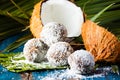 Coconut rum balls on green mat of palm leaves