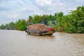 Wooden boat filled to capacity with coconut shells on distributary of Mekong Delta, Vietnam