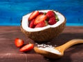 Coconut and strawberries on bright blue background Royalty Free Stock Photo