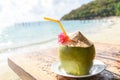 Coconut tropical fruit on table and sand beach background water - Fresh coconut juice summer with flower on beach sea in hot Royalty Free Stock Photo