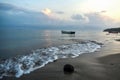 A coconut washed up on the beach with local fishing boats early morning sunrise Costa Rica