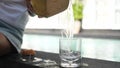 Coconut water pouring from fresh whole coconut into glass