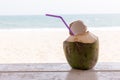 Coconut on wooden floor with sea background. Tropical fresh coconut cocktail decorated plumeria on white beach. Royalty Free Stock Photo