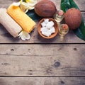 Coconuts, coconut oil and towels on vintage wooden background. Royalty Free Stock Photo