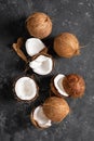 Coconuts cracked and whole on black background Royalty Free Stock Photo