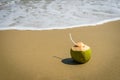 Coconuts with drinking straw on the sand