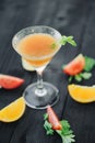 Coctail with orange and tomato on black wooden table at blurred background Royalty Free Stock Photo