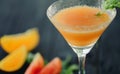 Coctail with orange and tomato on black wooden table at blurred background Royalty Free Stock Photo