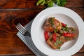 Cod fillet or other fish on a white plate. Braised in tomato and onion. Peas are sprinkled with green leaves and microgreen from Royalty Free Stock Photo