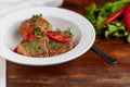 Cod fillet or other fish on a white plate. Braised in tomato and onion. Peas are sprinkled with green leaves and microgreen from Royalty Free Stock Photo