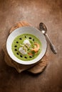 Cod fillet and shrimp over zucchini cream on wood background