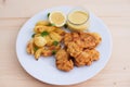 Cod fish in batter or cod fritters served with baked potatoes with parsley leaves and home made mayonnaise sauce. Royalty Free Stock Photo