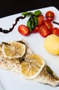 Cod fish dish with lemons and tomatoes Royalty Free Stock Photo