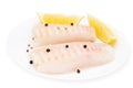 Cod fish loins raw pieces on the plate spiced with salt, peppercorns and lemon isolated on white background Royalty Free Stock Photo