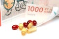 Cod liver oil omega 3 gel capsules with 1000 danish kroner currency bank note Royalty Free Stock Photo