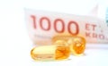 Cod liver oil omega 3 gel capsules with 1000 danish kroner currency bank note Royalty Free Stock Photo