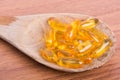 Cod liver oil omega 3 gel capsules on spoon wood Royalty Free Stock Photo