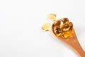 Cod liver oil omega 3 gel capsules in a wooden spoon Royalty Free Stock Photo