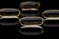 Cod liver vitamin D capsules on black reflective surface