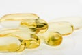 Cod liver vitamin D capsules on white reflective surface