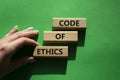 Code of ethics symbol. Concept words Code of ethics on wooden blocks. Beautiful green background. Businessman hand. Business and Royalty Free Stock Photo