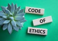 Code of ethics symbol. Concept words Code of ethics on wooden blocks. Beautiful green background with succulent plant. Business Royalty Free Stock Photo