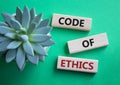 Code of ethics symbol. Concept words Code of ethics on wooden blocks. Beautiful green background with succulent plant. Business Royalty Free Stock Photo