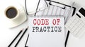 CODE OF PRACTICE text on the paper with calculator, notepad, coffee ,pen with graph Royalty Free Stock Photo