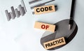 CODE OF PRACTICE wooden block on chart background Royalty Free Stock Photo