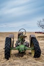 Coderre, SK- April 9, 2020: Vintage John Deere tractor abandoned in pasture on the prairies in Saskatchewan