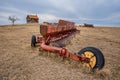 Coderre, SK- April 9, 2020: Vintage Massey-Ferguson discer abandoned in a pasture with a weathered farmhouse in Saskatch