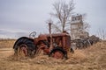 Coderre, SK- April 9, 2020: A vintage McCormick Deering tractor with the Coderre, Saskatchewan elevator in background