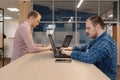 IT coders working on the laptop in the office standing at the table