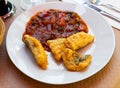 Codfish frying in batter and served with stewed ratatouille