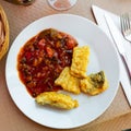 Codfish frying in batter and served with stewed ratatouille