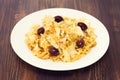 Codfish with potato chips and olives on white plate Royalty Free Stock Photo