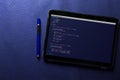 Coding and programming for web development and web design concept on tablet screen with blue pen on blue pattern Royalty Free Stock Photo