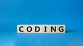 Coding symbol. Concept word Coding on wooden cubes. Beautiful blue background. Business and Coding concept. Copy space Royalty Free Stock Photo