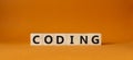 Coding symbol. Concept word Coding on wooden cubes. Beautiful orange background. Business and Coding concept. Copy space Royalty Free Stock Photo