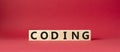 Coding symbol. Concept word Coding on wooden cubes. Beautiful red background. Business and Coding concept. Copy space Royalty Free Stock Photo