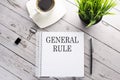Cofee cup, notepad,pen on the wooden background. Business concept. Text GENERAL RULE Royalty Free Stock Photo